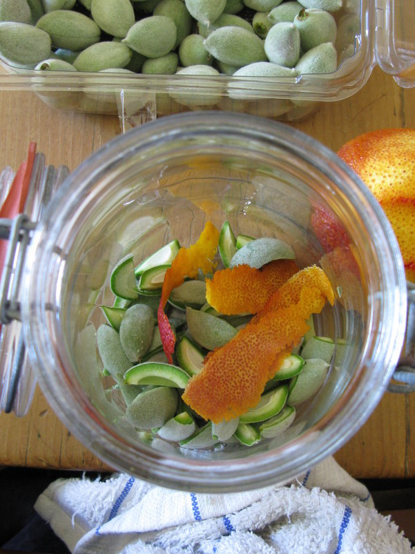 Adding flavorings to jar for green almond liqueur