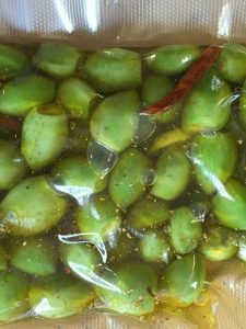 Olive oil and green almonds sealed in vacuum bag