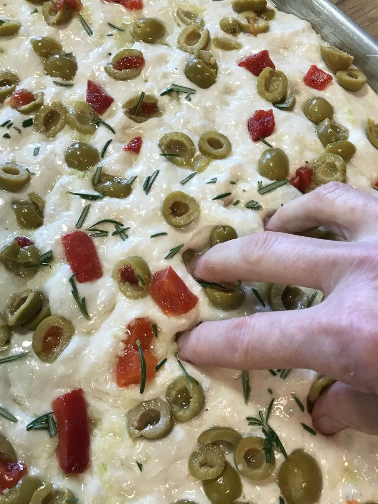 Dimpling the Olive Rosemary Focaccia dough right before baking