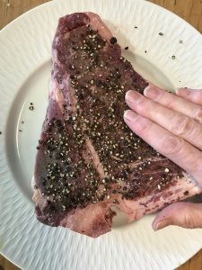 Pressing peppercorns into meat